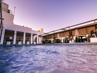 A Building With A Pool In Front
