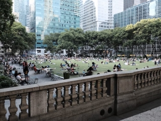 A Group Of People Sitting On A Bench In A Park