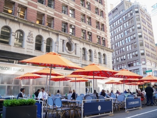 A Group Of People Sit Outside Of A Building