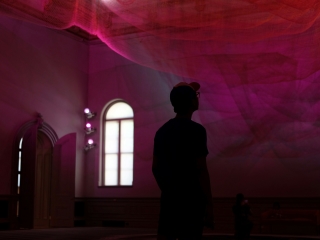 A Man Standing In A Room With A Pink Light