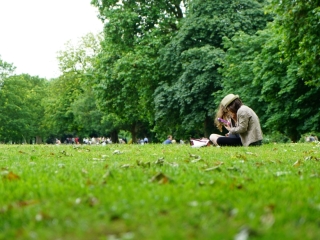 A Person Sitting In A Grassy Field