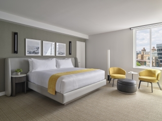 A Bedroom With A Bed And Chairs