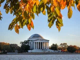 A Building With Columns And A Dome By A Body Of Water