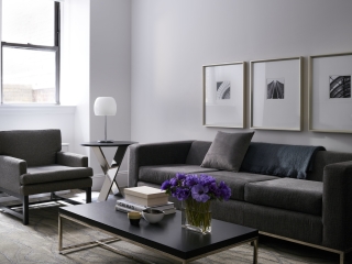 living room with dark gray couches and sun coming through the window