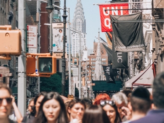 A Crowd Of People Walking Through A City
