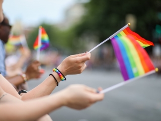 A Woman Holding A Rainbow Colored Kite