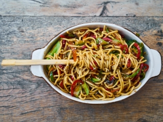 A Bowl Of Noodles With Chopsticks