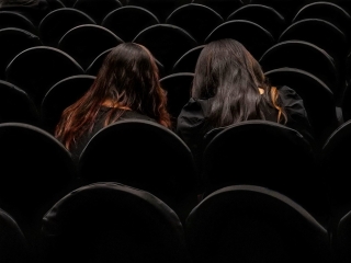 Two People Sitting In A Theater