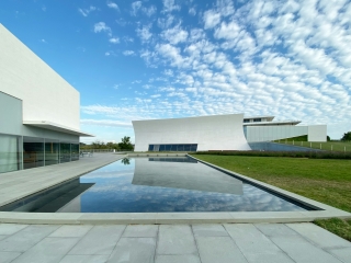 A Building With A Pool In Front