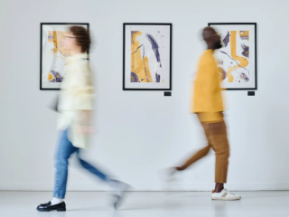 A Man And A Woman Walking Through A Gallery