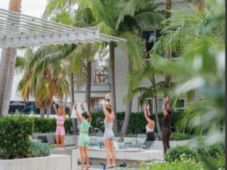 A Group Of People Standing On A Stone Ledge With Palm Trees